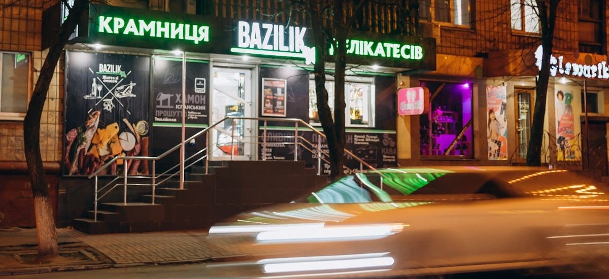 cars parked in front of store during night time